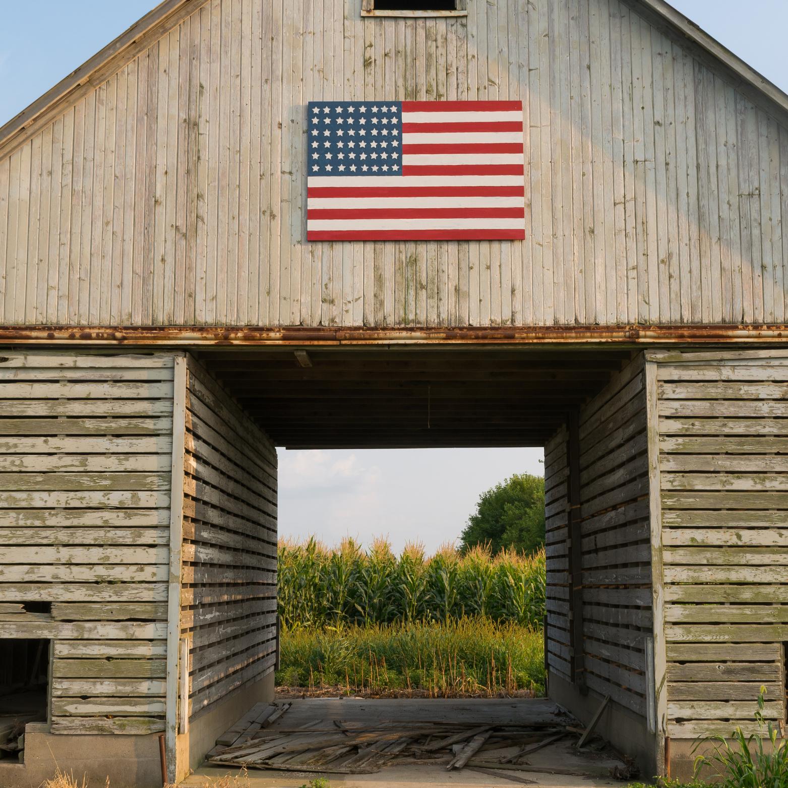 Weathered barn with a large painted American flag